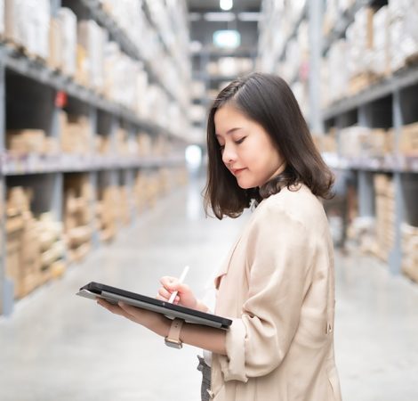 Pretty worker checking stock in the warehouse. Asian beautiful young woman worker of furniture store.Businesswoman using tablet in distribution stock.